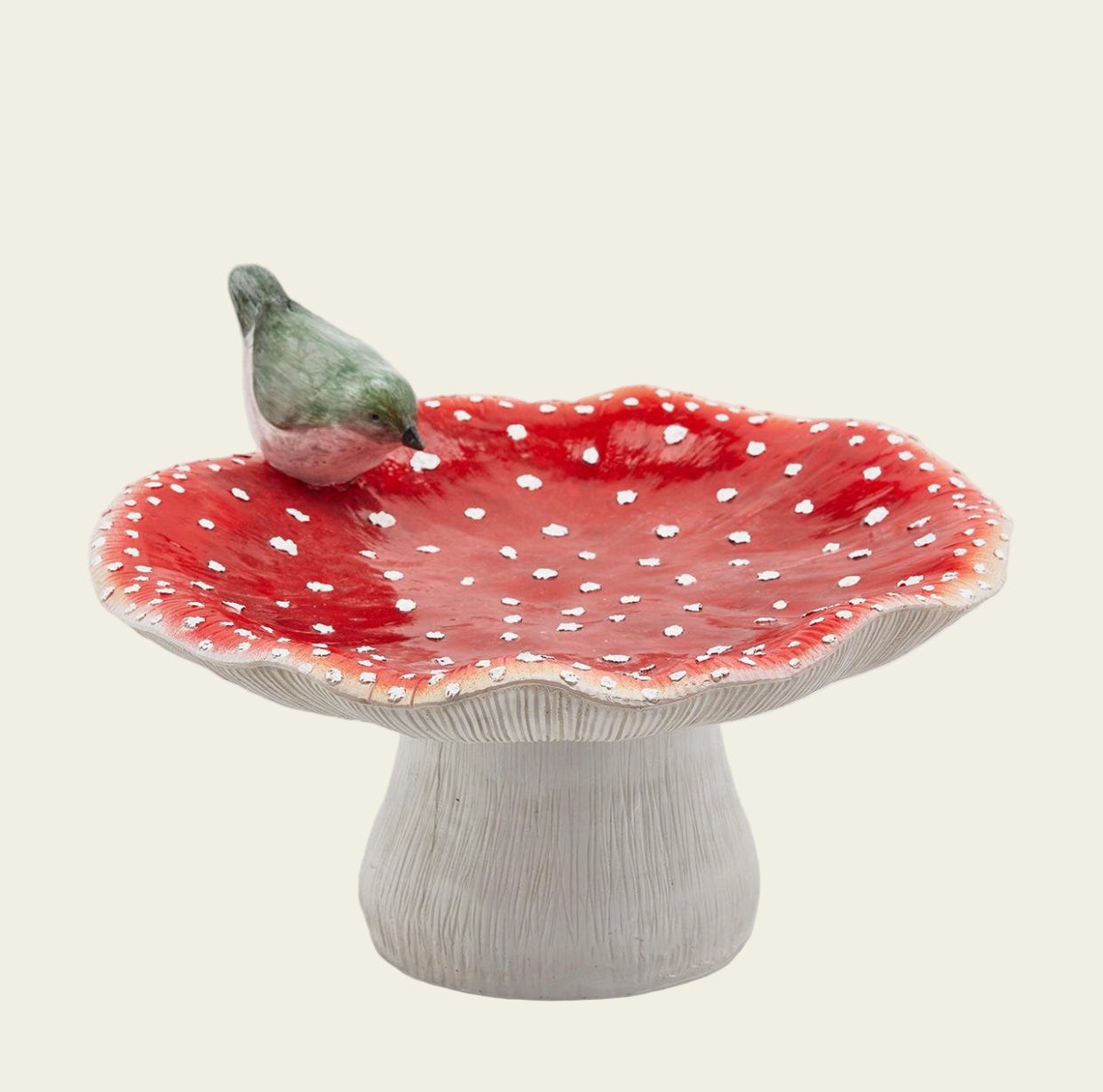 Ceramic bird bath with red spotted design on a white background