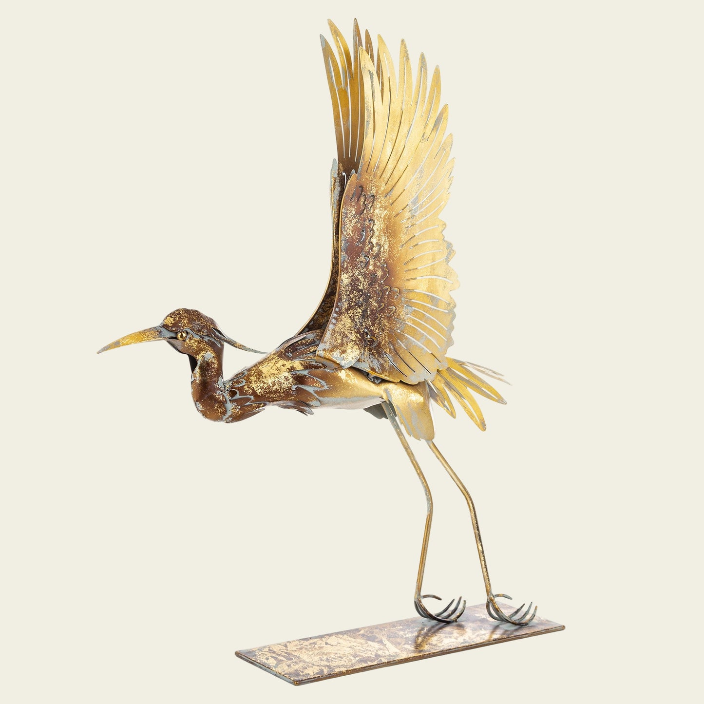 Decorative metal sculpture of a crane with gold and bronze finish on a white background