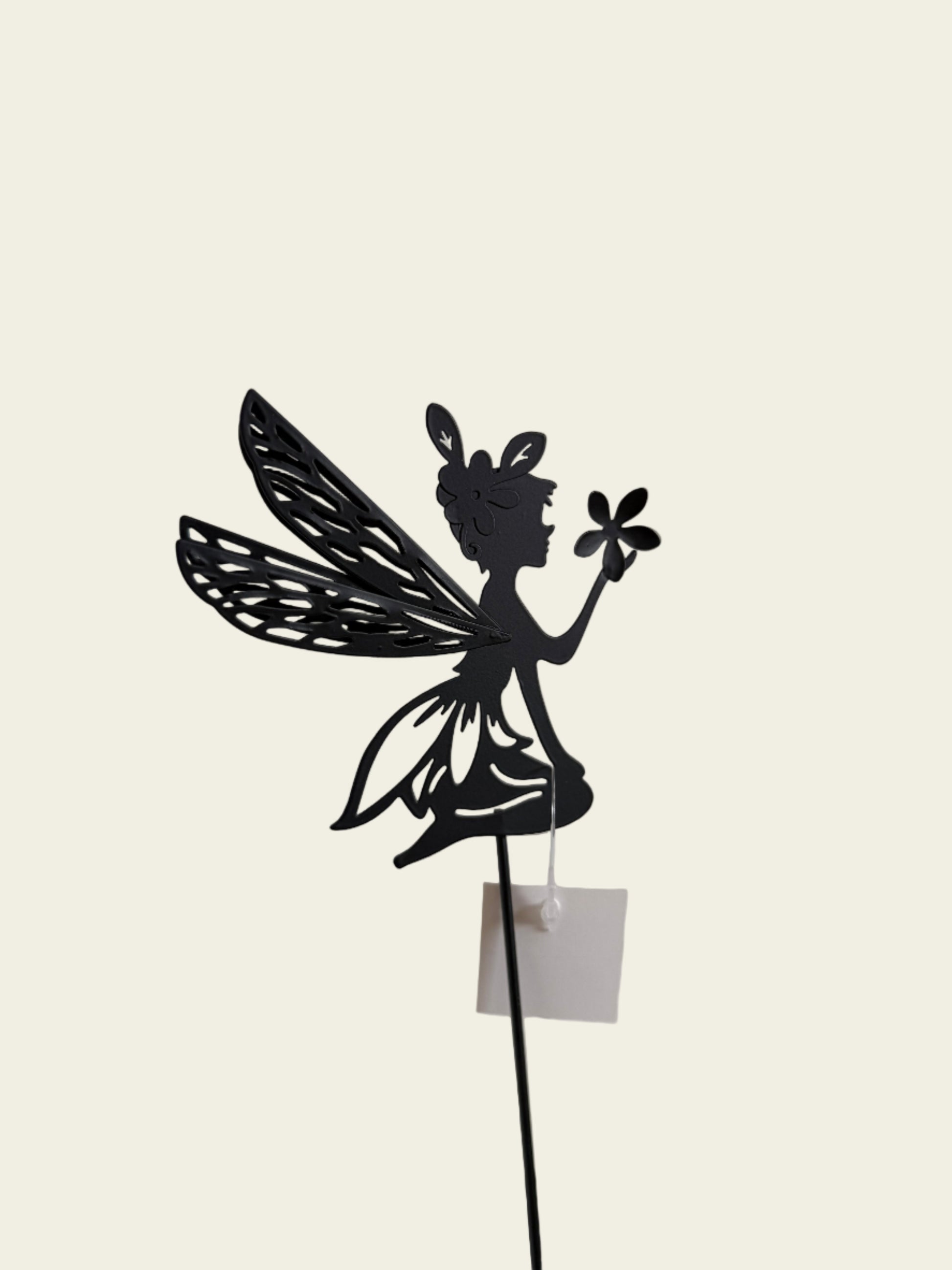 Decorative black metal flower sculpture on a white tiled wall.