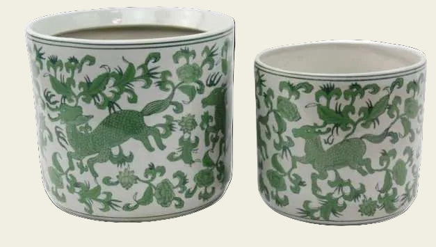 Two ceramic planters with green animal designs on a white background
